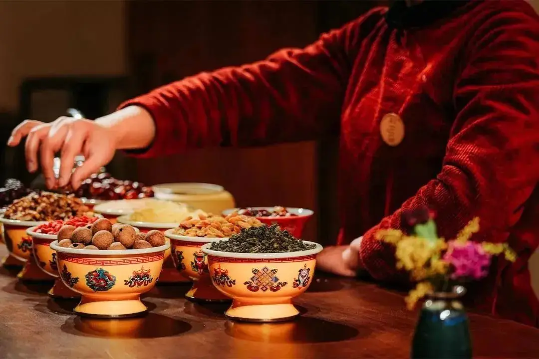Eight-treasure tea: red dates, longan, goji, tea leaves and dried fruit in decorated bowls