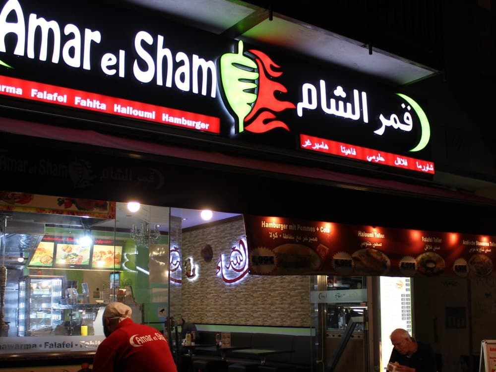 Amar el Sham, a halal shawarma shop in Berlin: black sign with Arabic and dish names, no green and no 清真