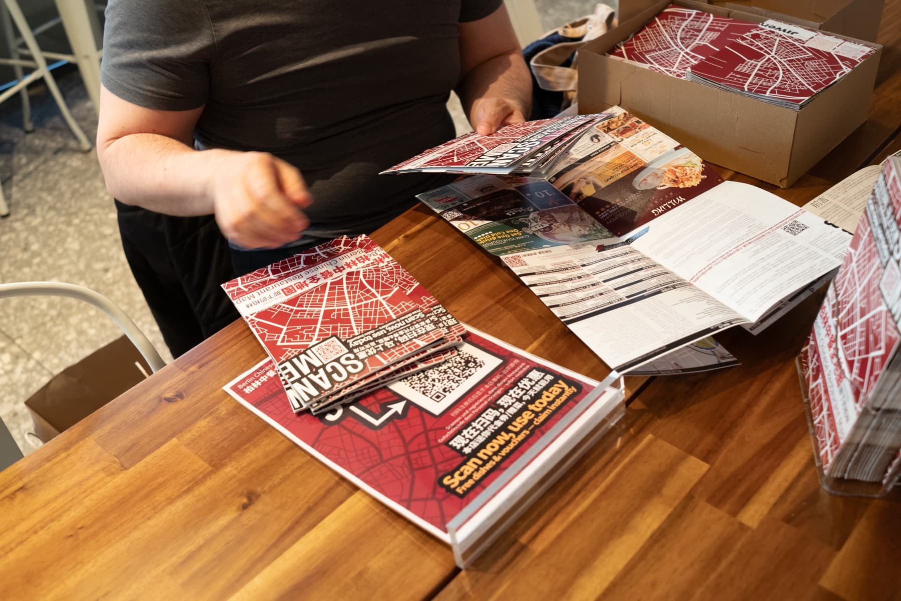 Gedruckte Berlin Chinese Food Maps und Kartenmaterial auf einem Tisch