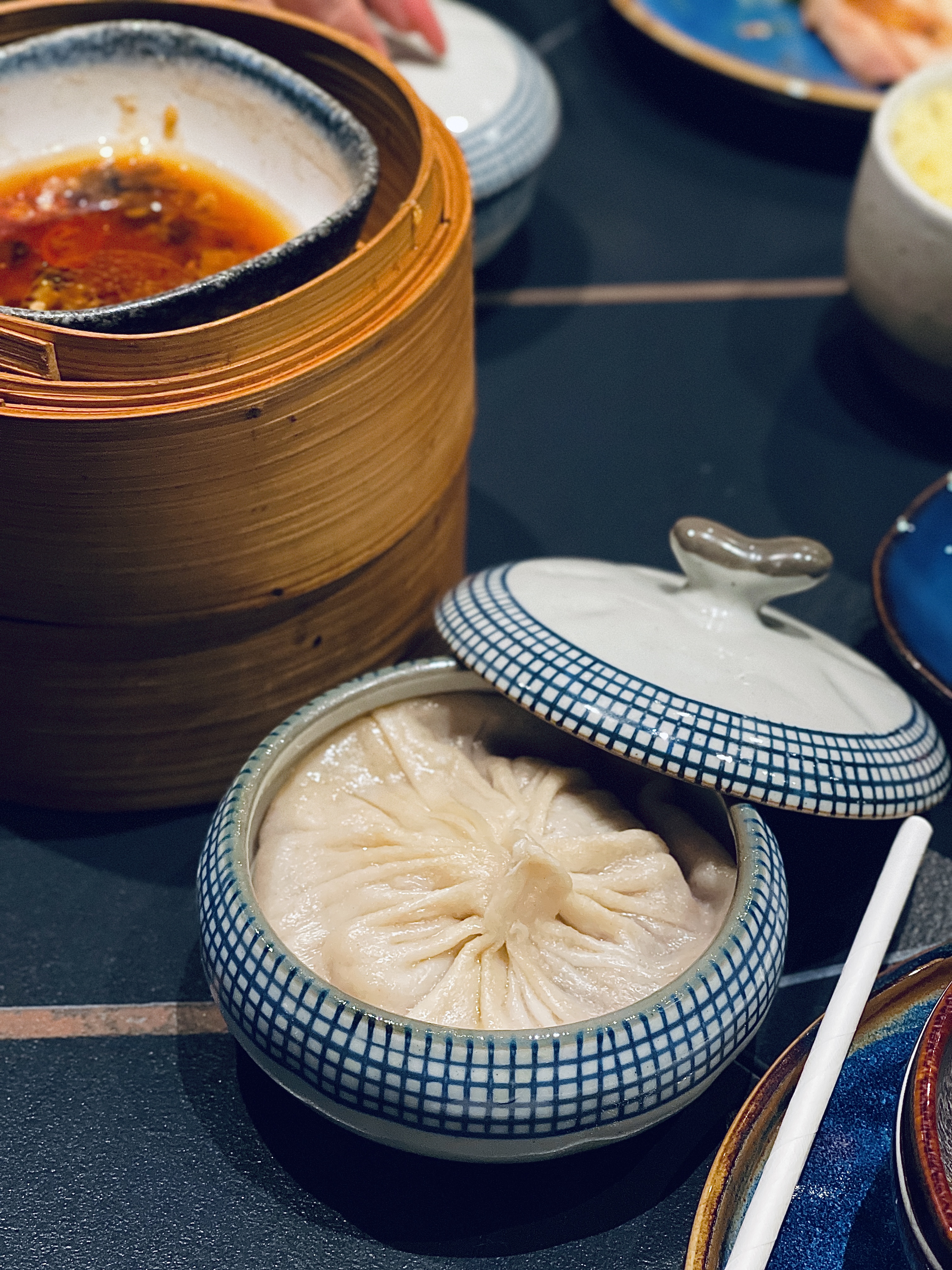 A large soup dumpling in a blue-and-white bowl at Ni’s Restaurant
